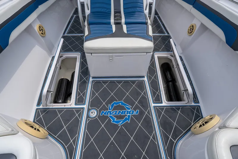 Slide: The Image of 2018 Fountain 38 Center Console boat interior with blue seating and storage compartments. - 23
