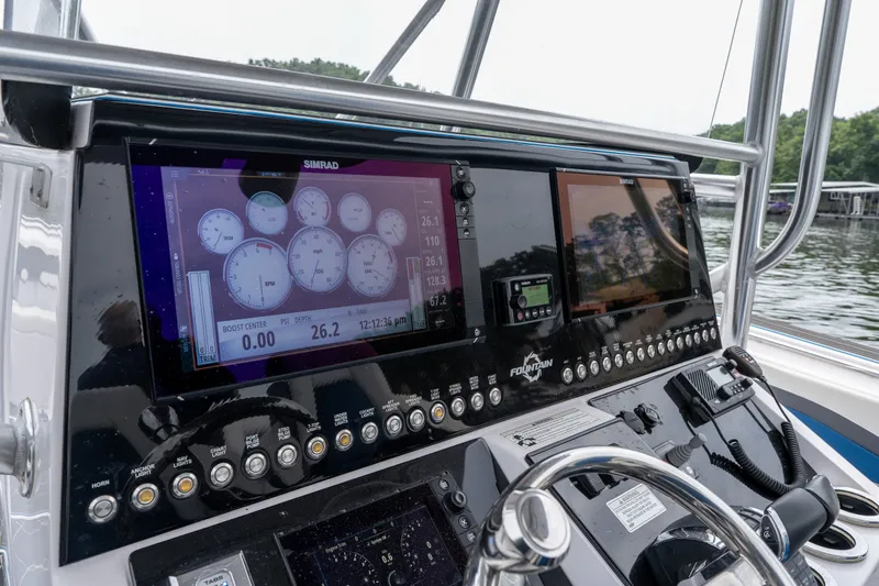 Slide: The Image of 2018 Fountain 38 Center Console dashboard with Simrad displays on a lake. - 37