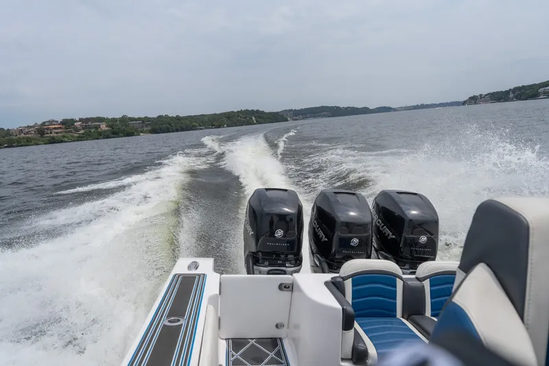 Slide: The Image of 2018 Fountain 38 Center Console boat with triple Mercury engines cruising on a lake. - 24