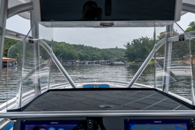 Slide: The Image of 2018 Fountain 38 Center Console navigating a scenic lake with lush greenery. - 33