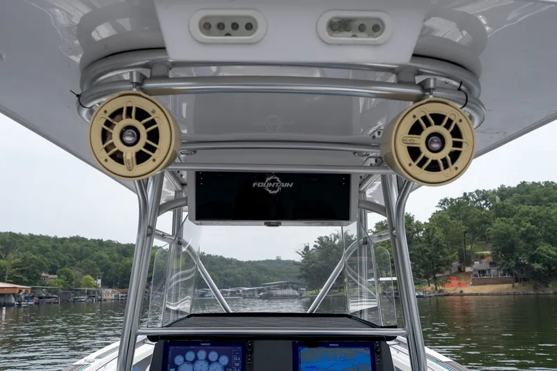Slide: The Image of 2018 Fountain 38 Center Console boat interior with speakers and navigation system on a lake. - 40