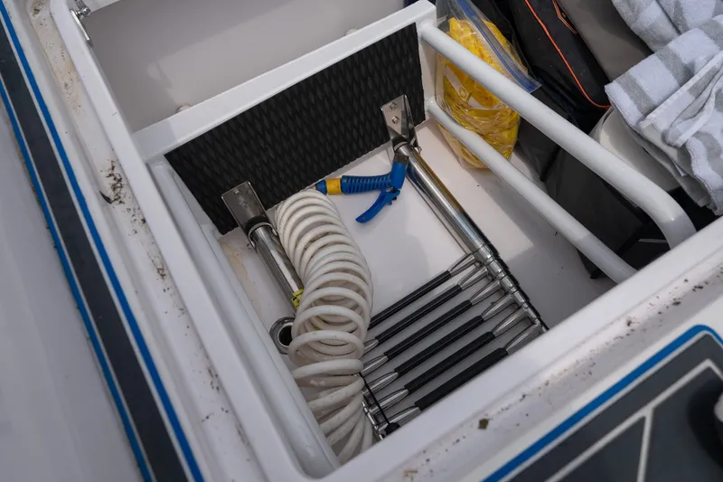 Slide: The Image of Storage compartment in 2018 Fountain 38 Center Console boat with hose and accessories. - 51