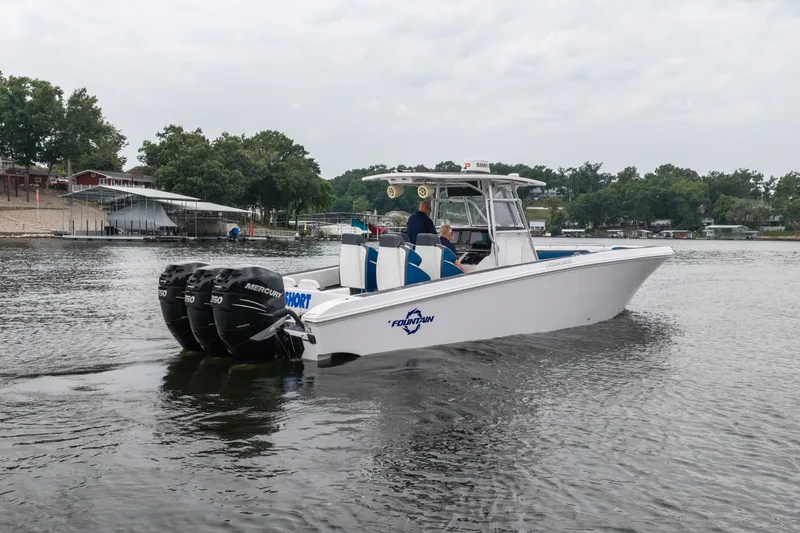 Slide: The Image of 2018 Fountain 38 Center Console boat on a lake with triple Mercury engines. - 6
