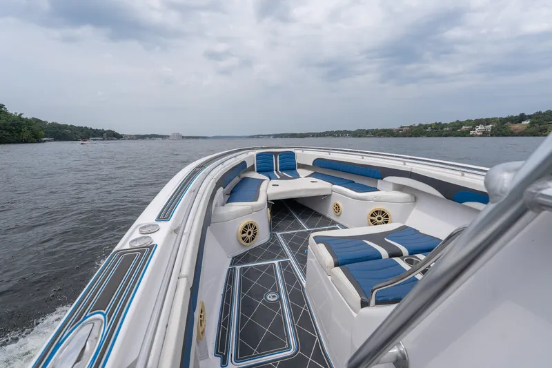 Slide: The Image of 2018 Fountain 38 Center Console boat with blue seating on a calm lake. - 18