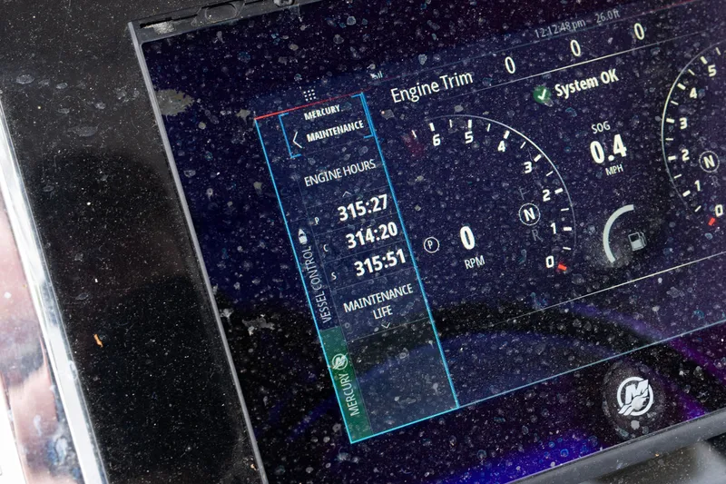 Slide: The Image of Close-up of a 2018 Fountain 38 Center Console boat dashboard display showing engine hours and system status. - 38