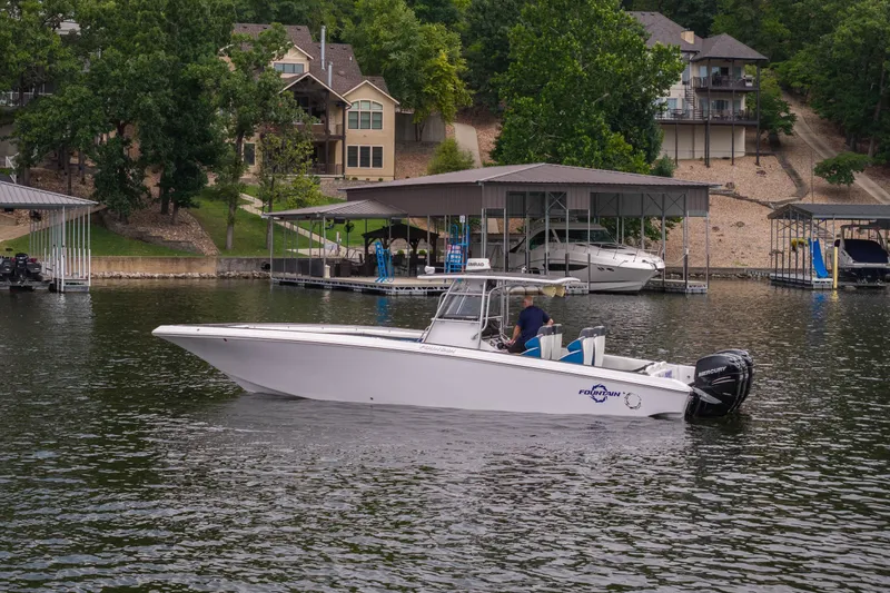 Slide: The Image of 2018 Fountain 38 Center Console boat on a lake near waterfront homes and docks. - 4