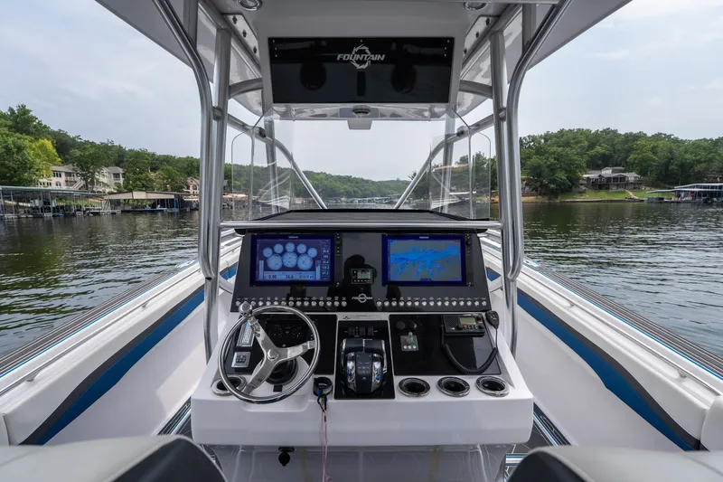 Slide: The Image of 2018 Fountain 38 Center Console boat dashboard with navigation screens on a serene lake. - 32