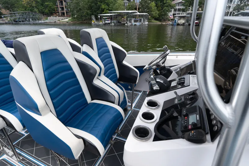 Slide: The Image of 2018 Fountain 38 Center Console boat interior with blue and white seating, steering wheel, and controls. - 43
