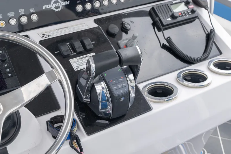Slide: The Image of Control panel of a 2018 Fountain 38 Center Console boat with steering wheel and throttle. - 35