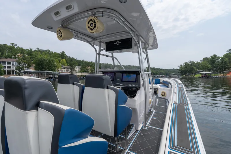 Slide: The Image of 2018 Fountain 38 Center Console boat interior with modern seating and navigation system on a lake. - 42