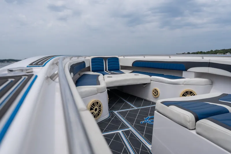Slide: The Image of 2018 Fountain 38 Center Console boat interior with blue and white seating, under cloudy sky. - 19