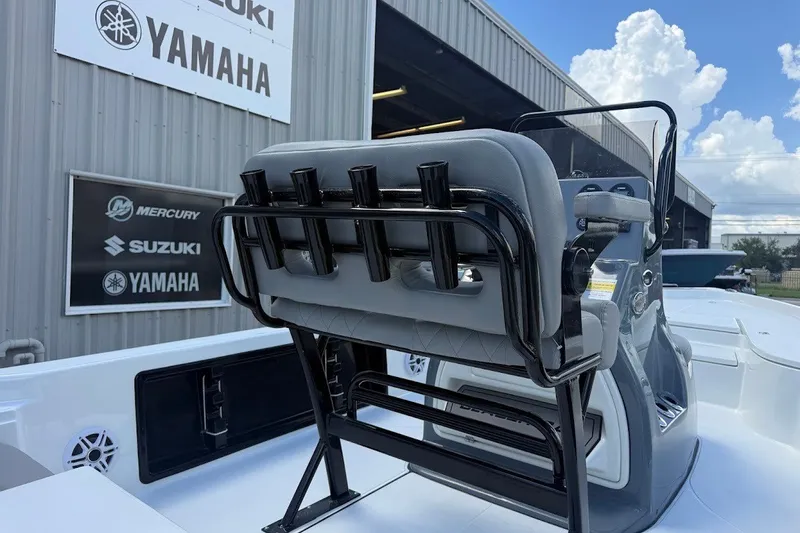Slide: The Image of 2027 Blazer PureBay 2200 boat with rod holders, near Yamaha dealership signs. - 13