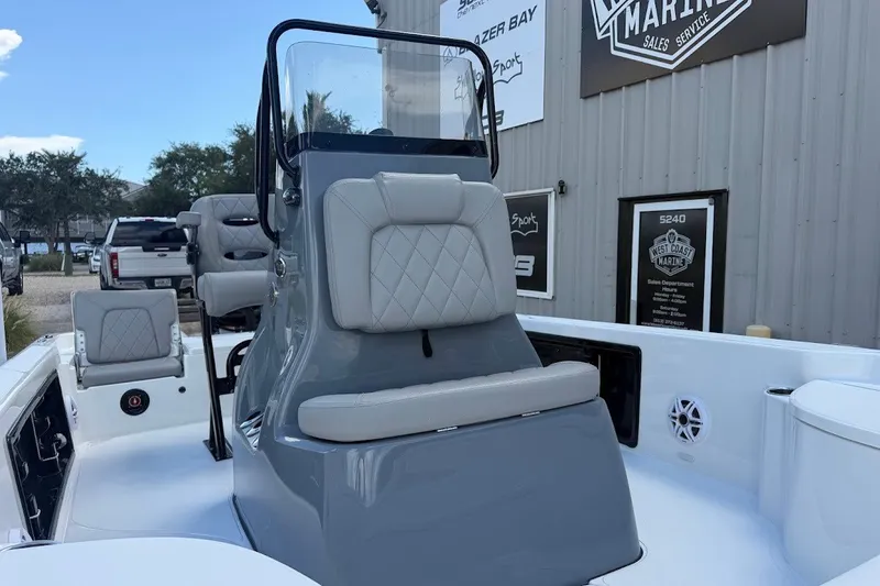 Slide: The Image of 2027 Blazer PureBay 2200 boat interior with gray seating and console at a marine dealership. - 4