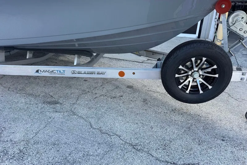 Slide: The Image of Trailer with Magic Tilt branding for 2027 Blazer PureBay 2200 boat on concrete surface. - 2