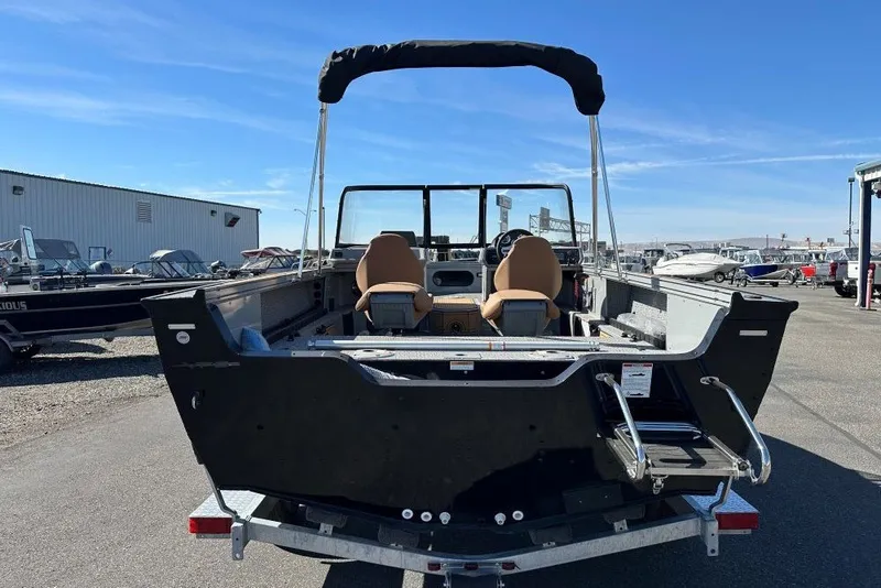 Slide: The Image of 2026 Starweld 18 SXR Sport boat, rear view, parked outdoors under clear blue sky. - 3