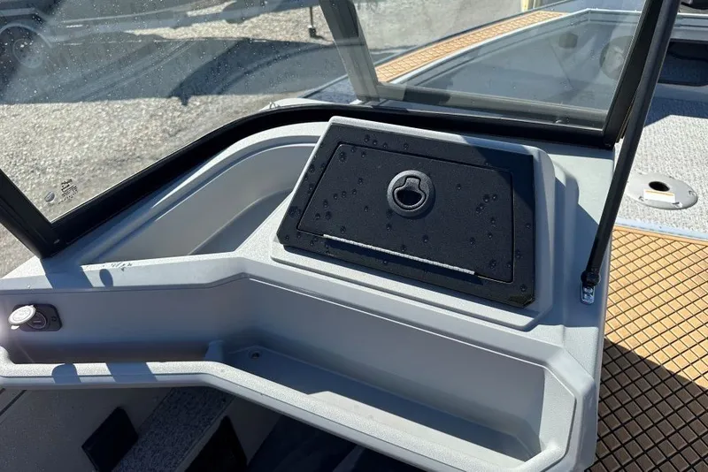 Slide: The Image of 2026 Starweld 18 SXR Sport boat dashboard with storage compartment and windshield. - 7