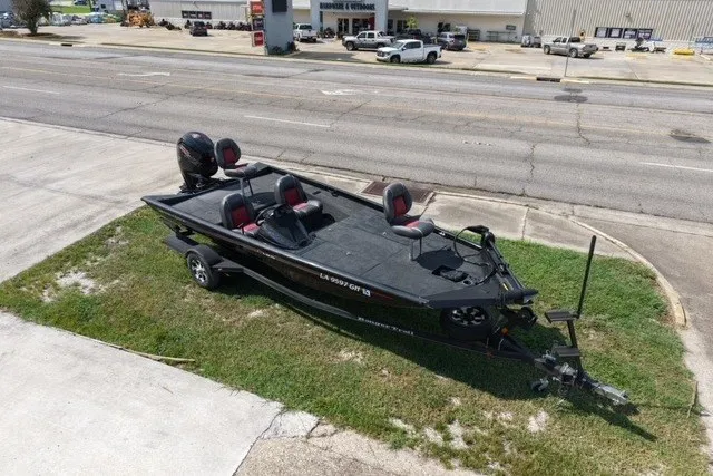 Slide: The Image of 2018 Ranger RT188 boat parked on grass near a road, featuring dual seats and an outboard motor. - 3