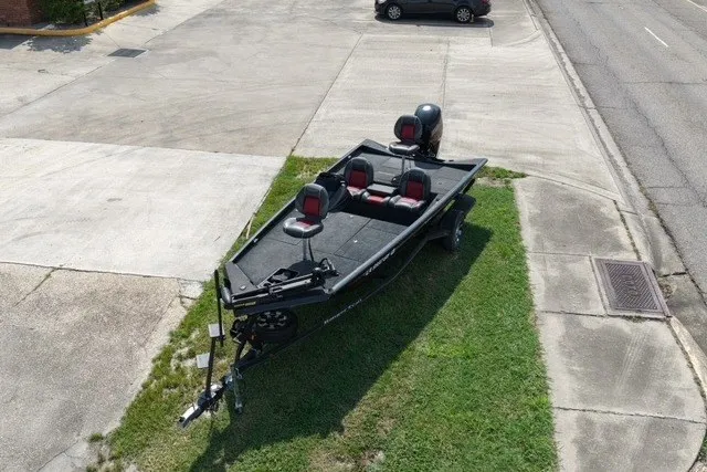 Slide: The Image of 2018 Ranger RT188 boat parked on grass, featuring three seats and an outboard motor. - 4