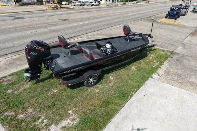 Slide: The Image of 2018 Ranger RT188 boat on trailer, parked on grass beside a road. - 2