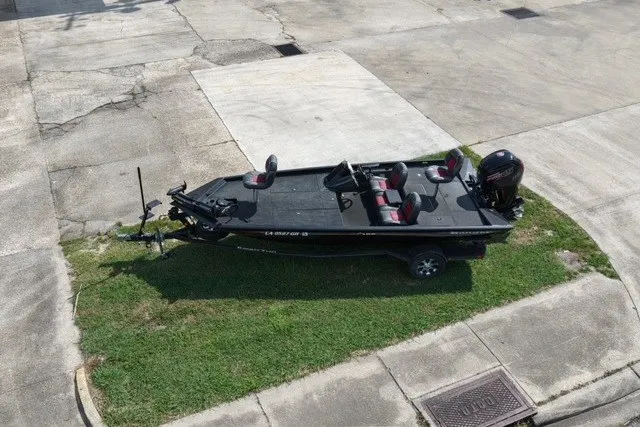 Slide: The Image of 2018 Ranger RT188 boat parked on grass, featuring a sleek black design and red-accented seats. - 5