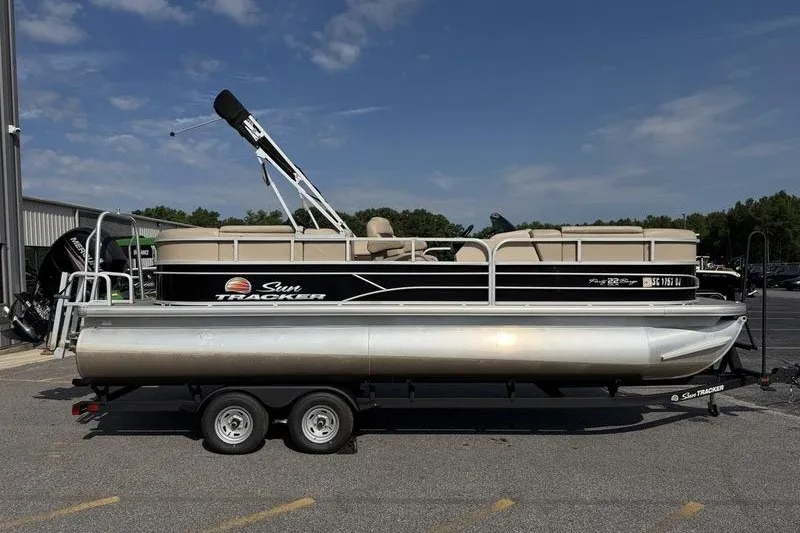 The Image of 2018 Sun Tracker Party Barge 22 DLX pontoon boat on trailer, parked outdoors. - 0