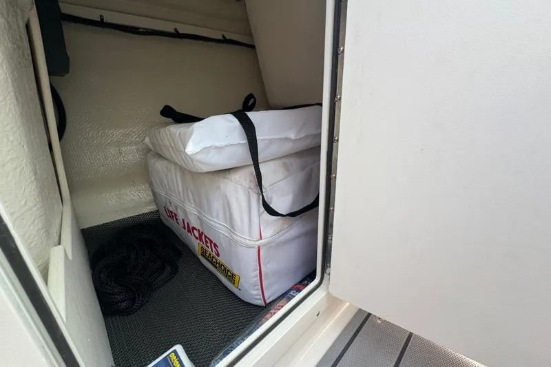 Slide: The Image of Storage compartment in 2023 Chaparral 21 SSi boat with life jackets and rope. - 22