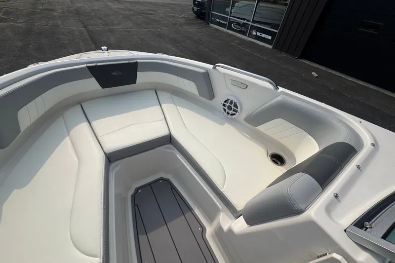 Slide: The Image of 2023 Chaparral 21 SSi boat interior with white and gray seating, speaker, and storage. - 16
