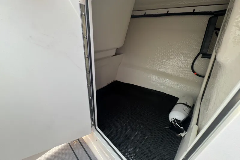 Slide: The Image of 2023 Chaparral 21 SSi boat interior storage compartment with fire extinguisher. - 21