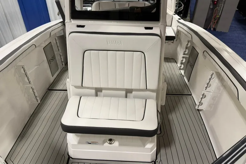 Slide: The Image of 2025 Yamaha Boats 255 FSH Sport E interior with white seating and sleek design. - 20