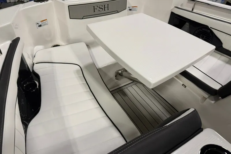 Slide: The Image of 2025 Yamaha Boats 255 FSH Sport E interior with white seating and table. - 17