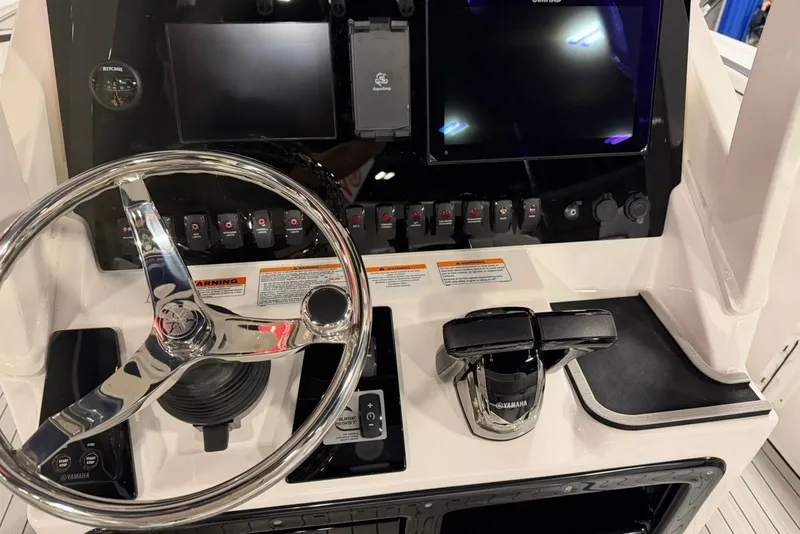 Slide: The Image of Control panel of 2025 Yamaha Boats 255 FSH Sport E with steering wheel and digital displays. - 10