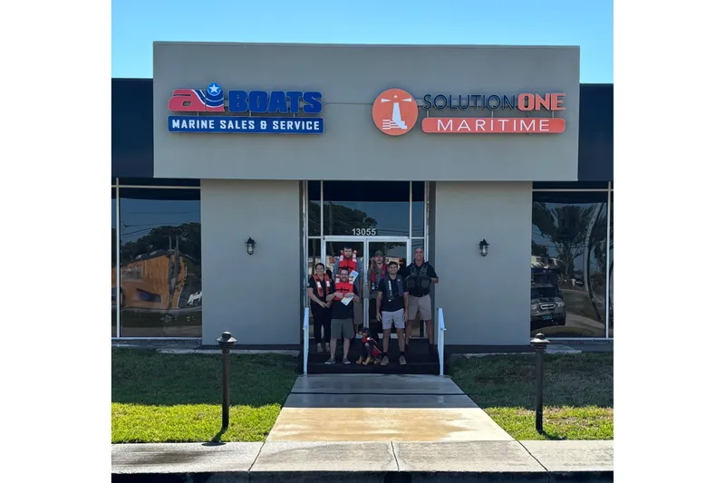 Slide: The Image of Exterior of AI Boats Marine Sales & Service building with Solution One Maritime signage. - 5