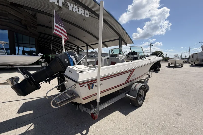 Slide: The Image of 1988 Wellcraft 200 Fisherman boat on trailer, parked outside a boat yard. - 2