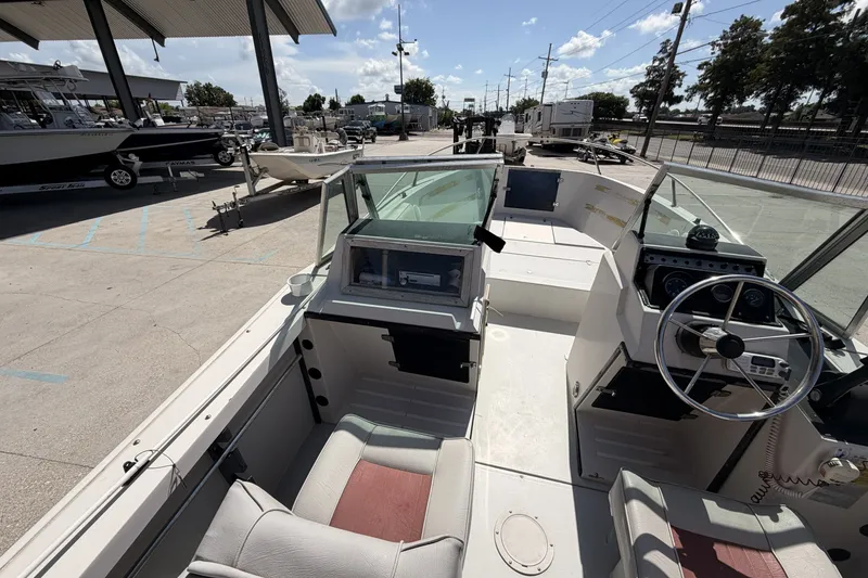 Slide: The Image of 1988 Wellcraft 200 Fisherman boat interior with steering wheel and seating, parked outdoors. - 15