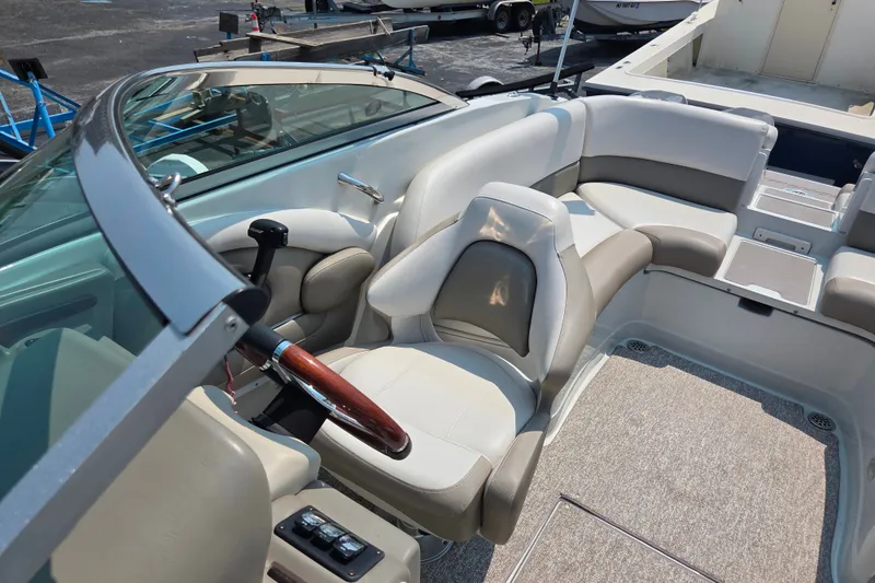 Slide: The Image of 2015 Crownline 255 SS boat interior with plush seating and sleek steering wheel. - 25