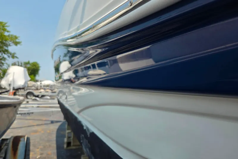Slide: The Image of 2015 Crownline 255 SS boat side view with sleek blue and white design. - 33