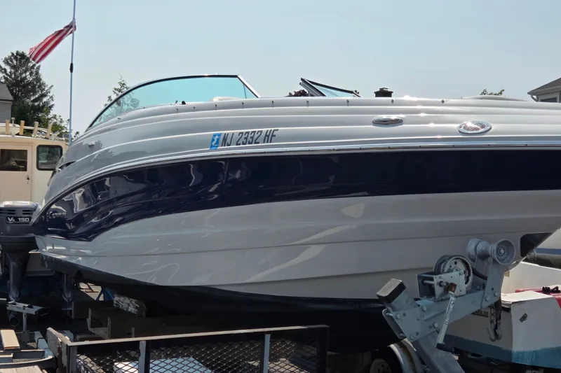 Slide: The Image of 2015 Crownline 255 SS boat on trailer, displaying sleek design and registration number. - 11