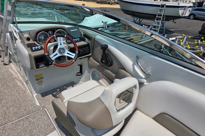 Slide: The Image of Interior of a 2015 Crownline 255 SS boat, featuring a sleek dashboard and steering wheel. - 28