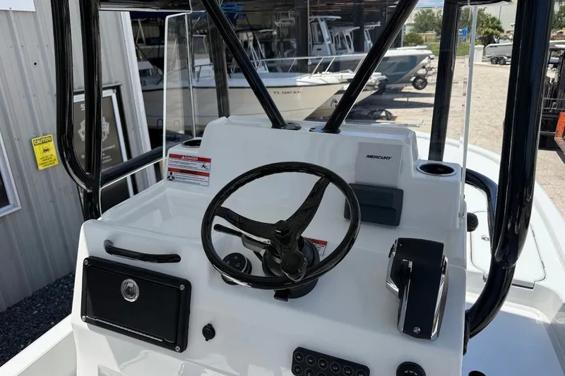 Slide: The Image of 2027 Shallow Sport 25 X3 boat console with steering wheel and Mercury controls. - 13