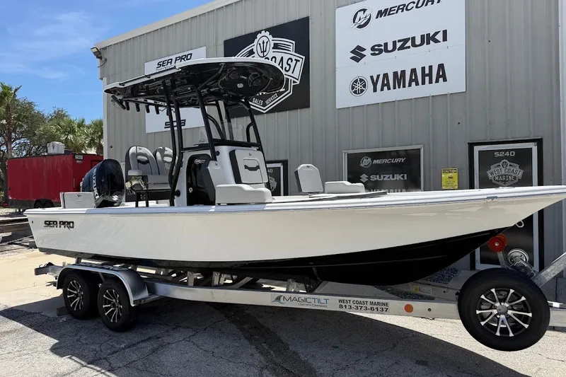The Image of 2027 Sea Pro 230 Bay boat on trailer outside marine dealership. - 1
