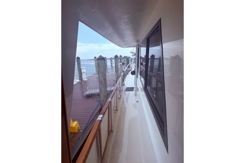 Slide: The Image of 1981 Hatteras 56 Motor Yacht docked, showcasing side deck and railing. - 4