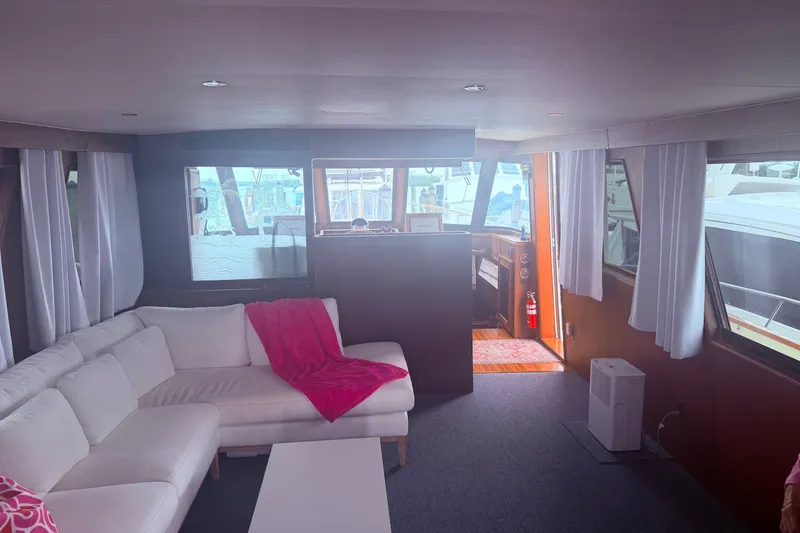 Slide: The Image of Interior of 1981 Hatteras 56 Motor Yacht with white sofa and pink blanket. - 9