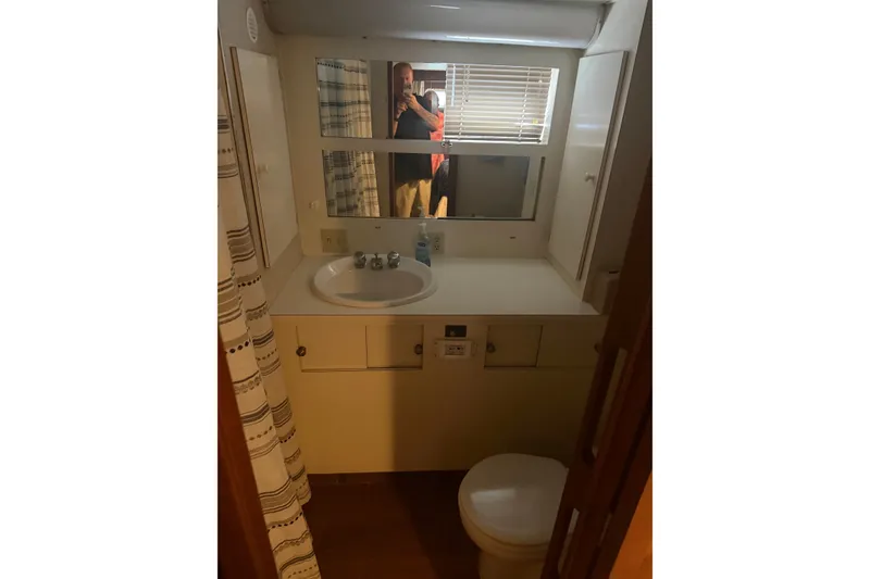 Slide: The Image of Bathroom interior of 1981 Hatteras 56 Motor Yacht with sink, mirror, and shower curtain. - 12