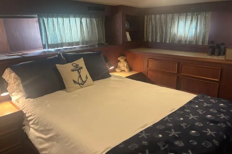 Slide: The Image of Cozy bedroom in 1981 Hatteras 56 Motor Yacht with nautical decor and wood paneling. - 10