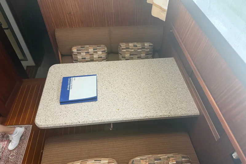 Slide: The Image of Dining area in 1981 Hatteras 56 Motor Yacht with table and manual. - 22