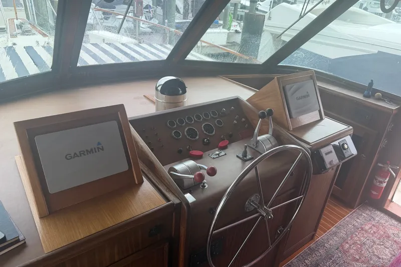 Slide: The Image of Helm of 1981 Hatteras 56 Motor Yacht with Garmin navigation displays and classic controls. - 2