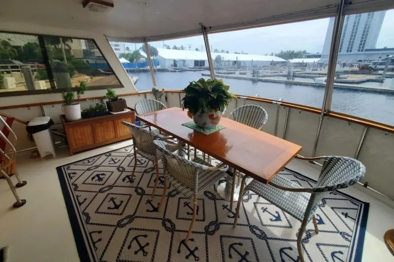 Slide: The Image of Elegant dining area on 1981 Hatteras 56 Motor Yacht with waterfront view. - 24