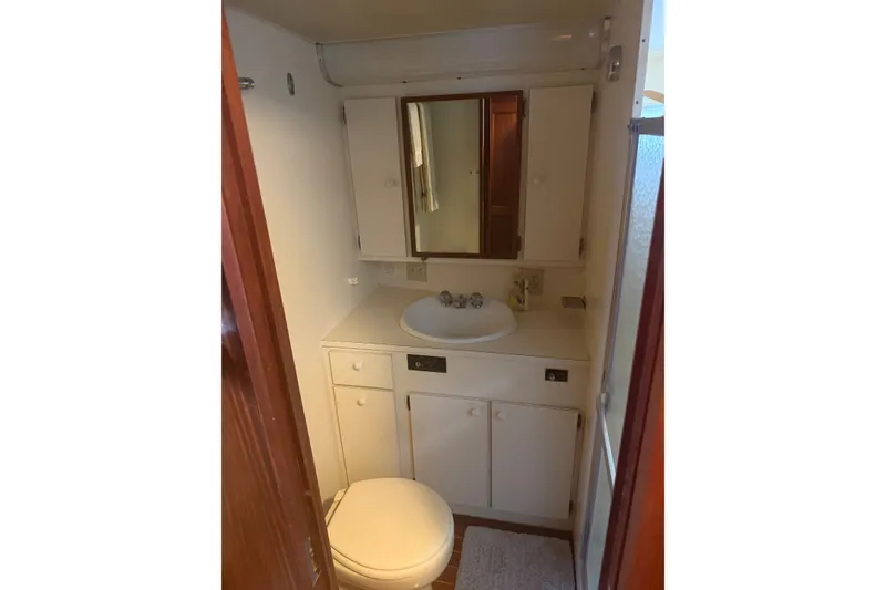 Slide: The Image of Compact bathroom in 1981 Hatteras 56 Motor Yacht with sink, mirror, and toilet. - 18