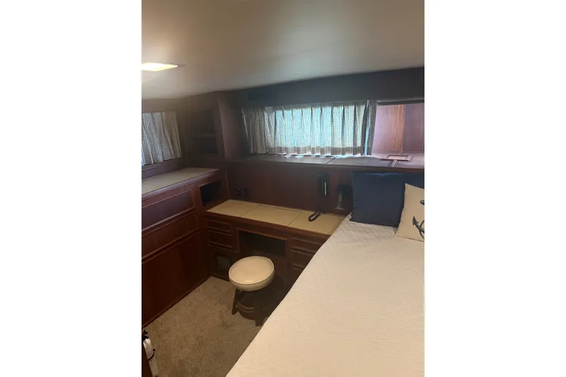 Slide: The Image of Interior of 1981 Hatteras 56 Motor Yacht with wooden cabinetry and cozy sleeping area. - 14