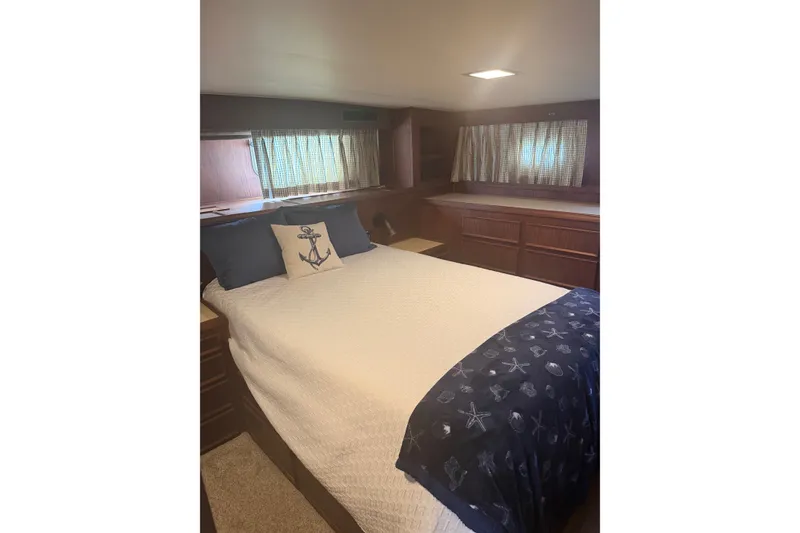 Slide: The Image of Cozy bedroom interior of 1981 Hatteras 56 Motor Yacht with nautical-themed bedding. - 11